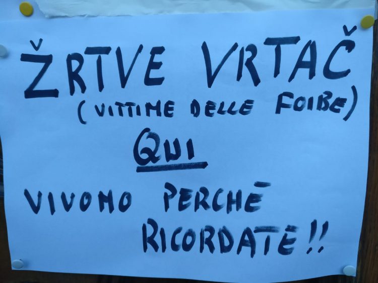 LA LOGGIA – Don Marini appende un altro cartello fuori dalla parrocchia per il ricordo delle vittime delle Foibe