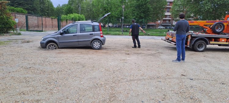 CARMAGNOLA – Entra nel parcheggio ma si incastra con la macchina in una buca non segnalata