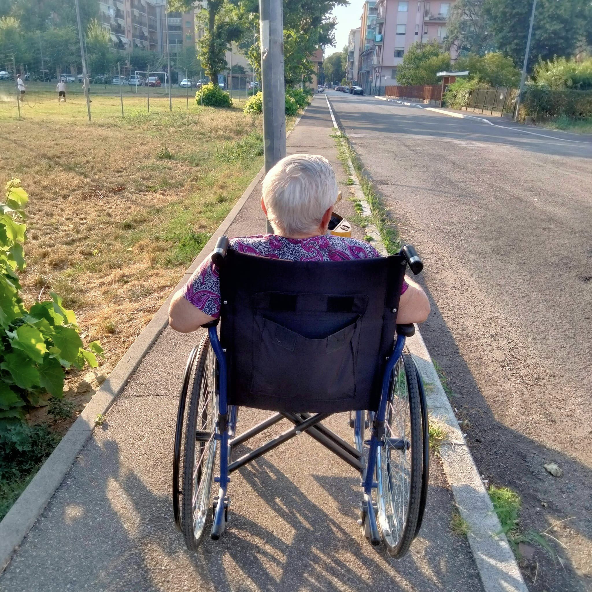 NICHELINO – Il palo della luce e il marciapiede stretto: la donna in carrozzina resta bloccata